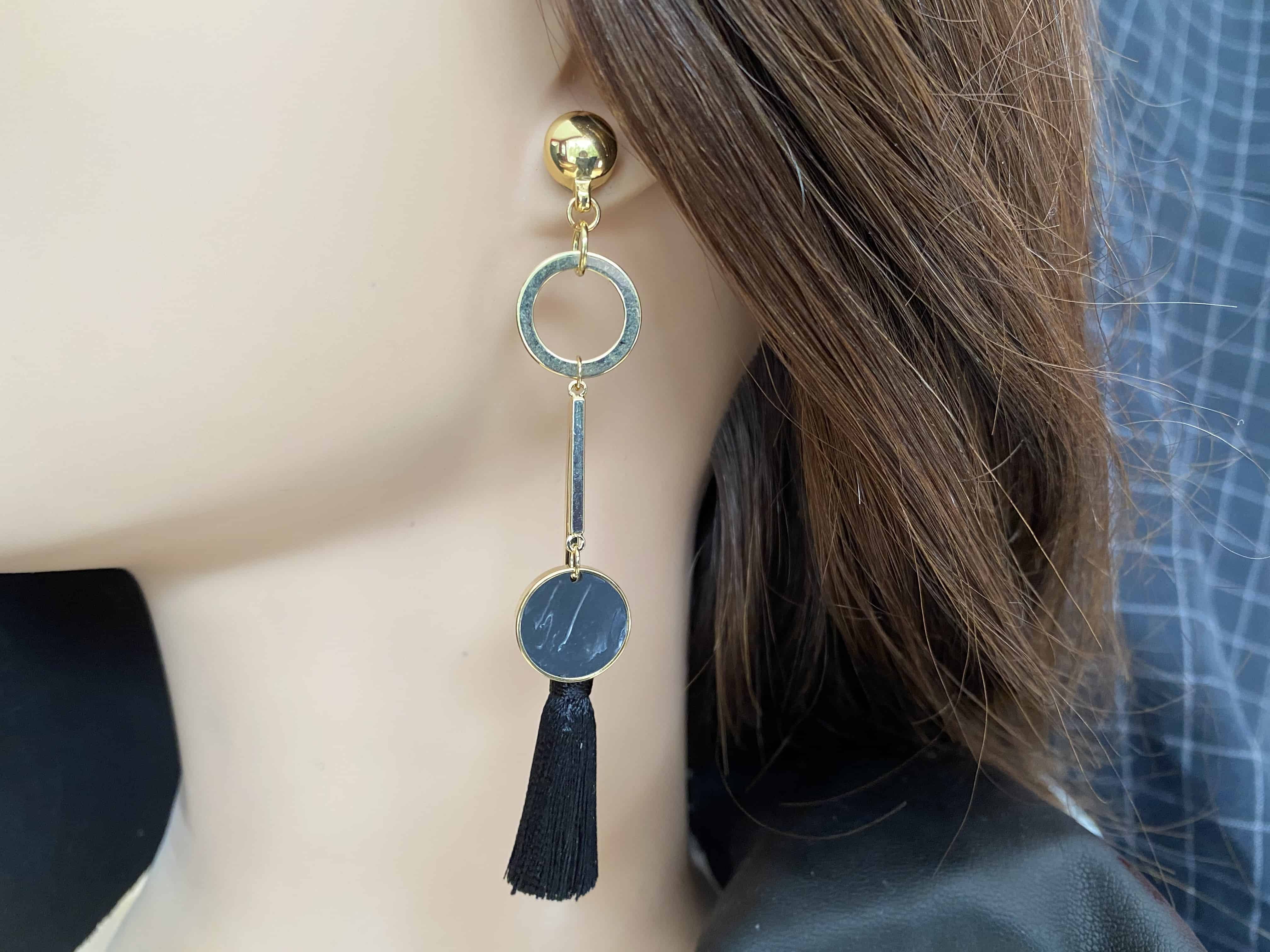 TI-GO Gold ring, bar, black and a hanging tussle earring.