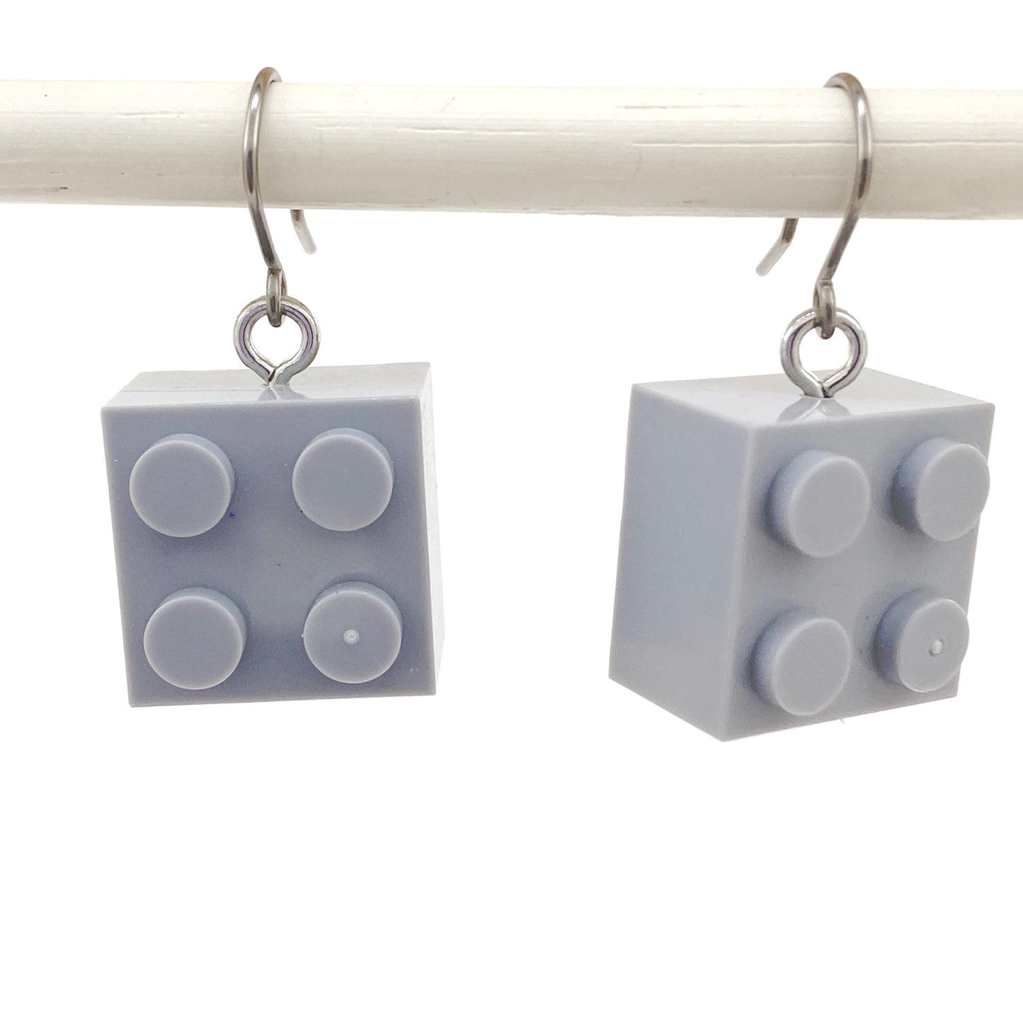 Lego block earrings with a titanium hook on a white background. grey