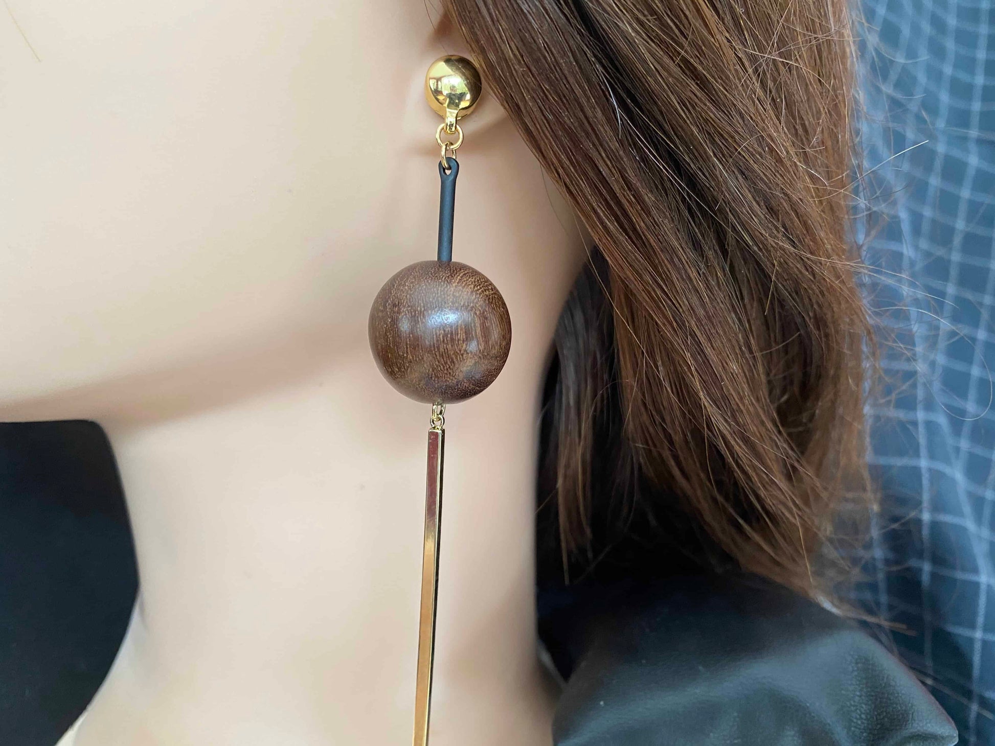 TI-GO Brown wooden ball and hanging golden bar. Magnetic titanium interchangeable earring system. Detachable earrings for a truly hypoallergenic jewellery on a white young woman.