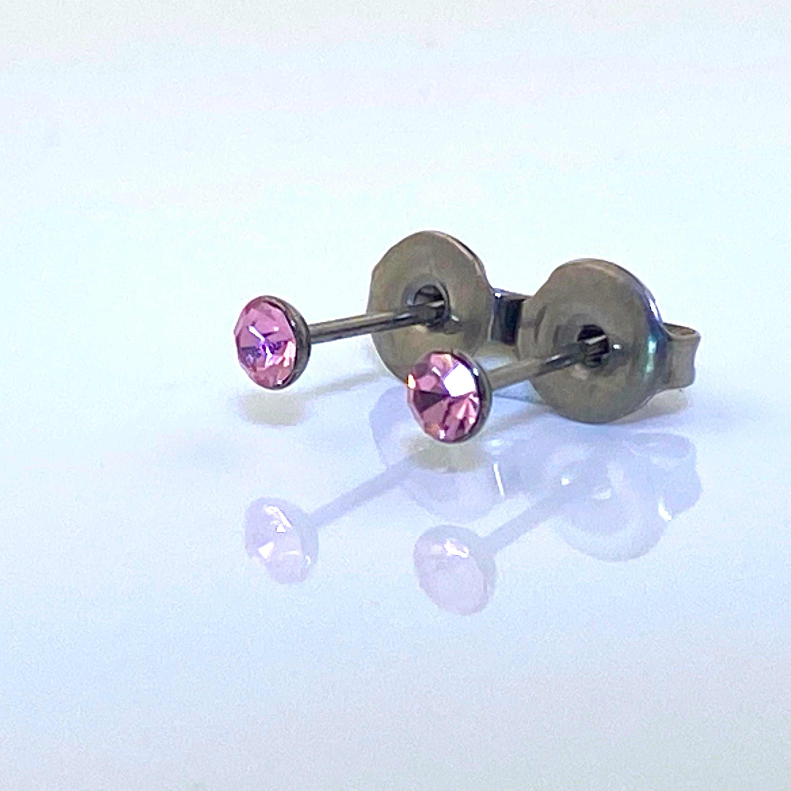 Pink Gem Studs -solid titanium studs and backs- Feature a small and minimal design on a white background reflected