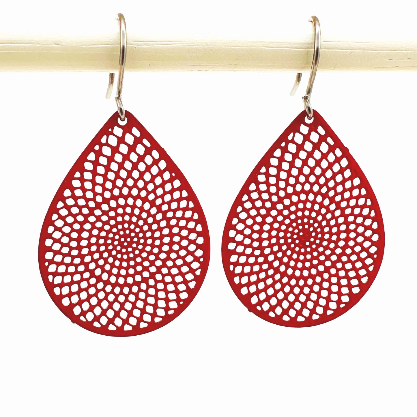 Red teardrop earrings with titanium hook. on a white background