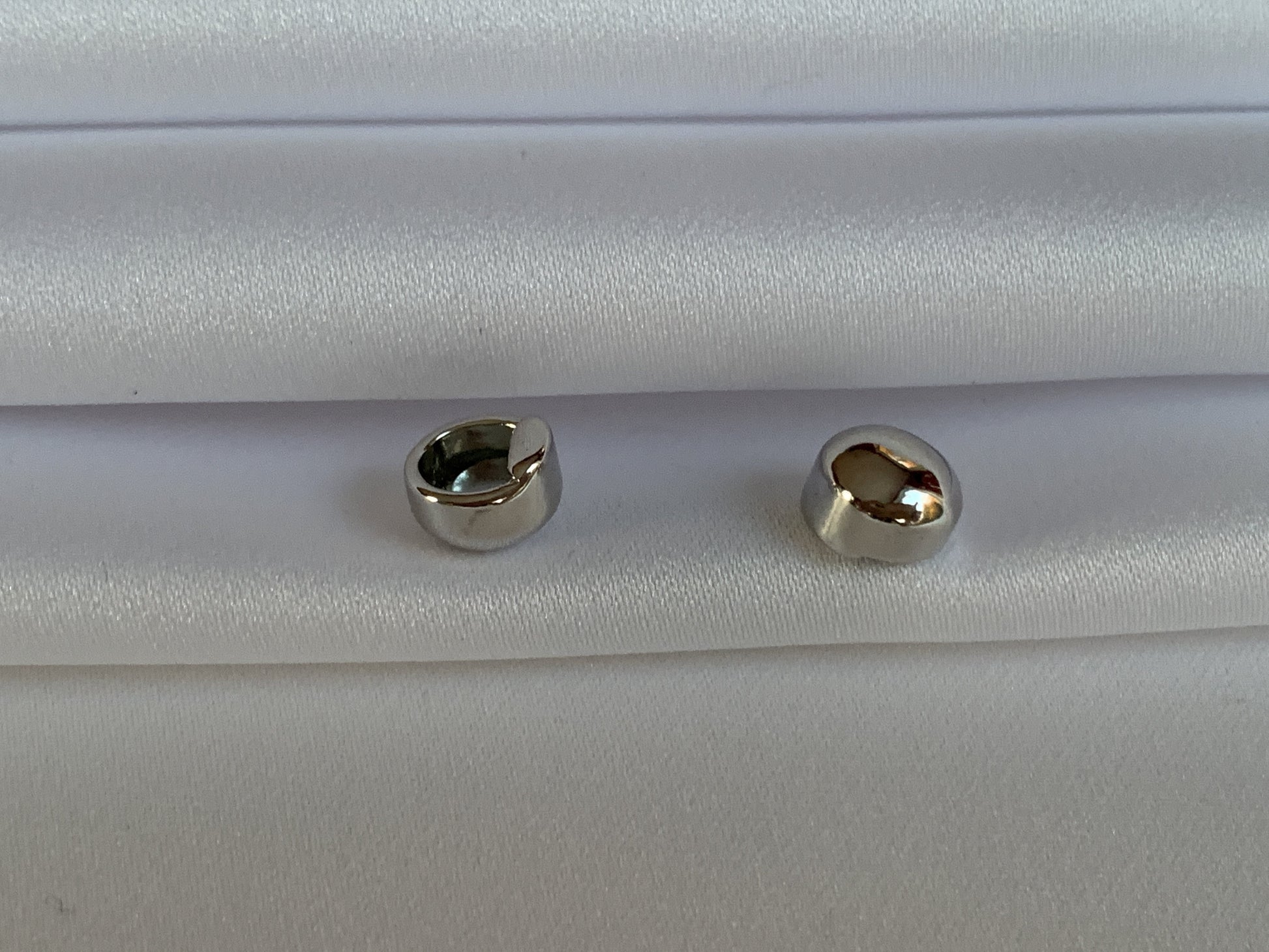 TI-GO Silver Stud Covers. Titanium Studs with titanium backs. These studs shown on a background