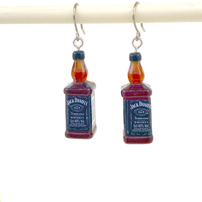 Whiskey drop earrings with titanium hook. on a white young woman.