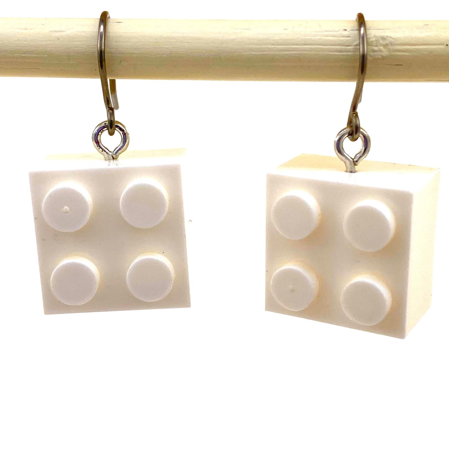 Lego block earrings with a titanium hook on a white background. white