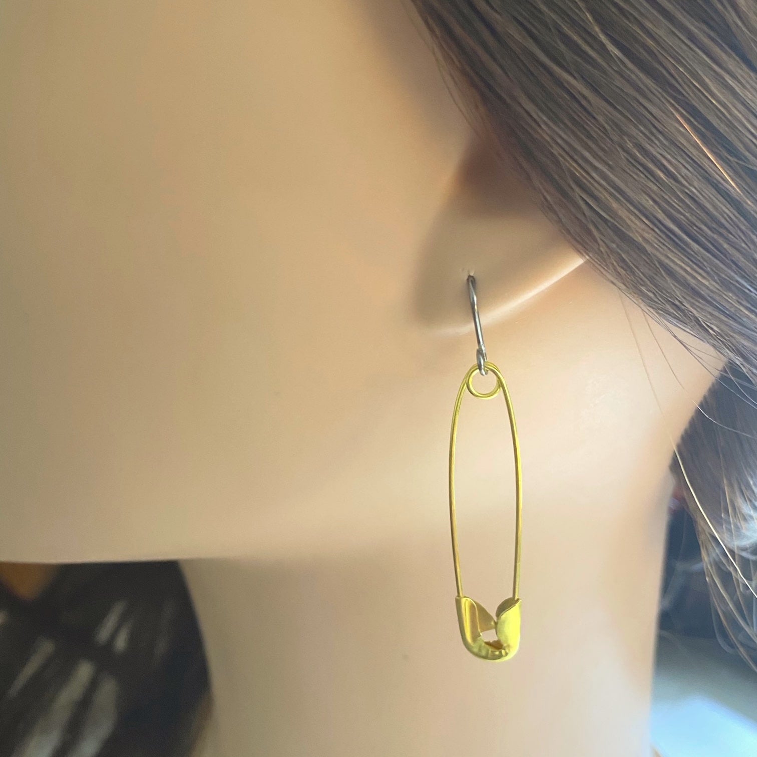 SafetyPin earrings with a titanium hook on a white young woman.