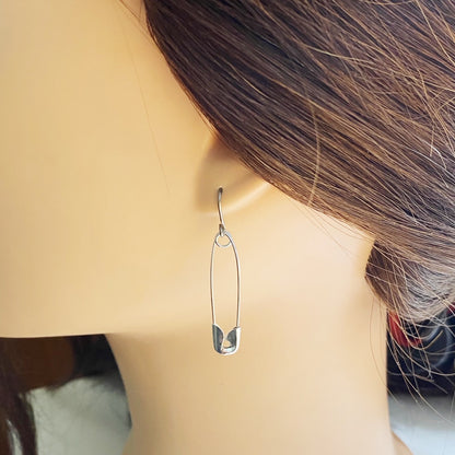 SafetyPin earrings with a titanium hook on a white young woman.