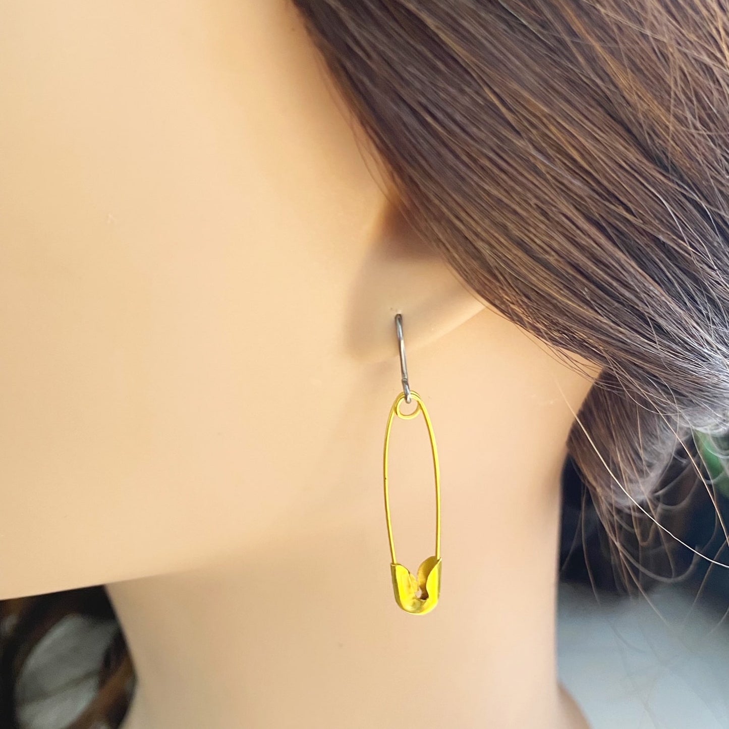 SafetyPin earrings with a titanium hook on a white young woman.