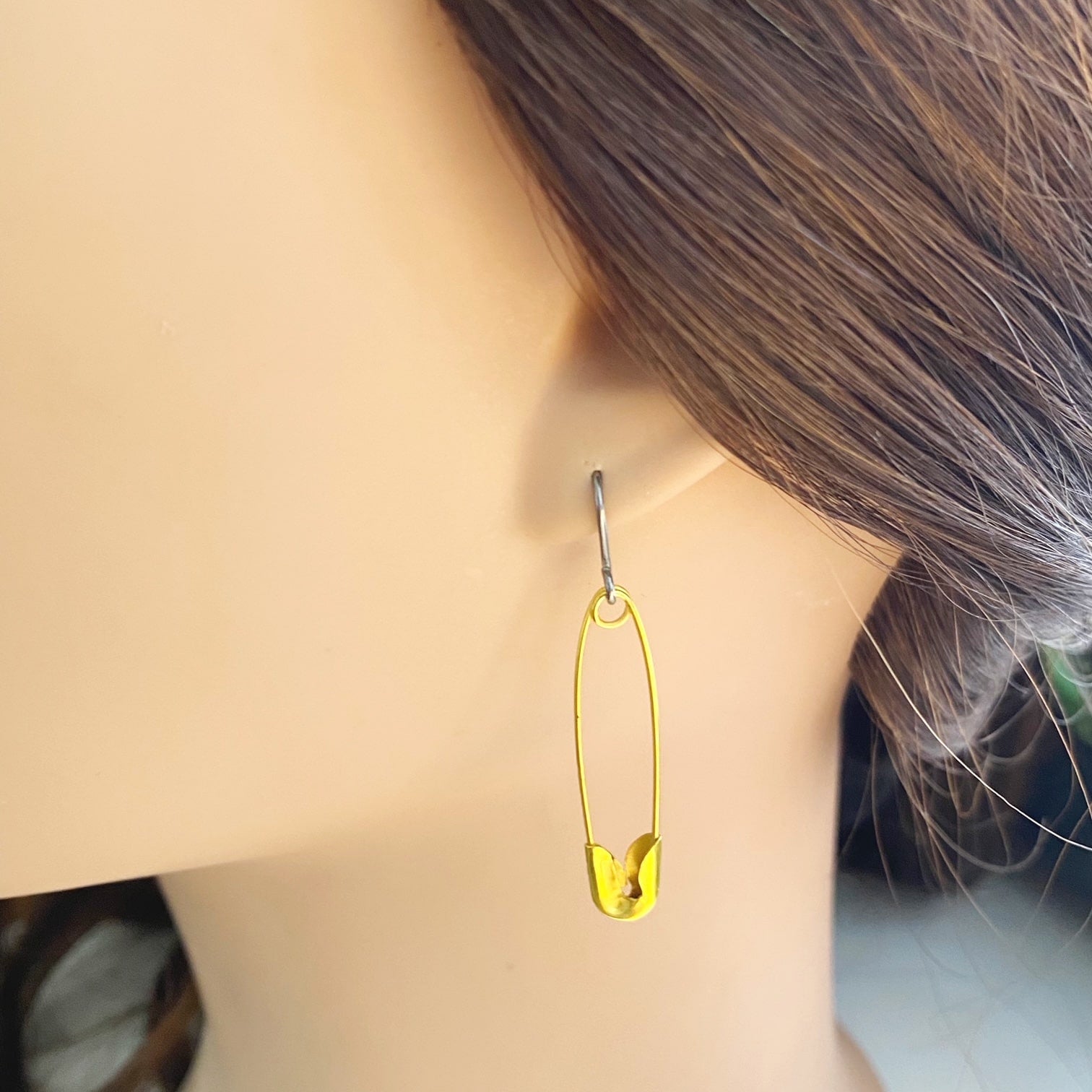 SafetyPin earrings with a titanium hook on a white young woman.